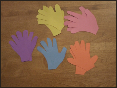 Lay Out 8 or More Colored Construction Paper Hands