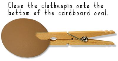 Close the clothespin onto the bottom of the cardboard oval