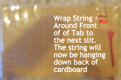 Wrap string around front of tab to the next slit.