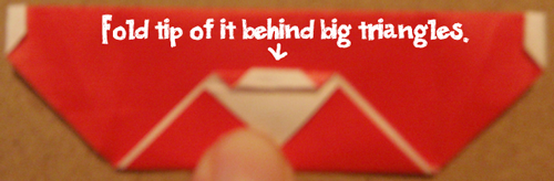 Fold tip of it behind big triangles.
