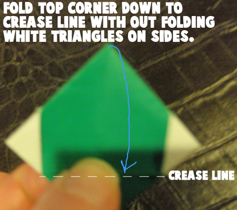 Fold top corner down to crease line without folding white triangles on sides.