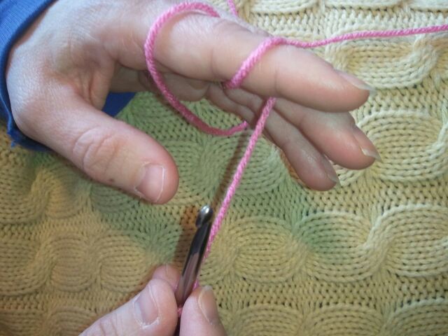 Wrap extra yarn around finger so that the yarn is pulled tight.