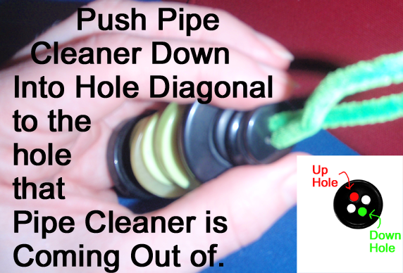 Push pipe cleaner down into hole diagonal to the hole that the pipe cleaner is coming out of.