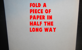 Fold a piece of paper in half the long ways.