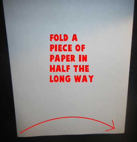 Fold a piece of paper in half the long ways.