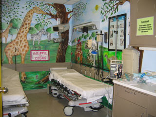 giraffes on the main wall and a part of the right wall where there is a monkey, trees, and a turtle can partially be seen on the right wall of Mt. Sinai's Pediatric ER Treatment Room