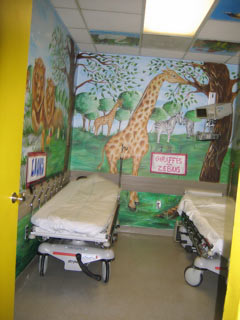 Look at this gorgeous, hand-painted wall that was beautifully painted by our volunteer artists where there is a monkey, trees, and a turtle can partially be seen on the right wall of Mt. Sinai's Pediatric ER Treatment Room